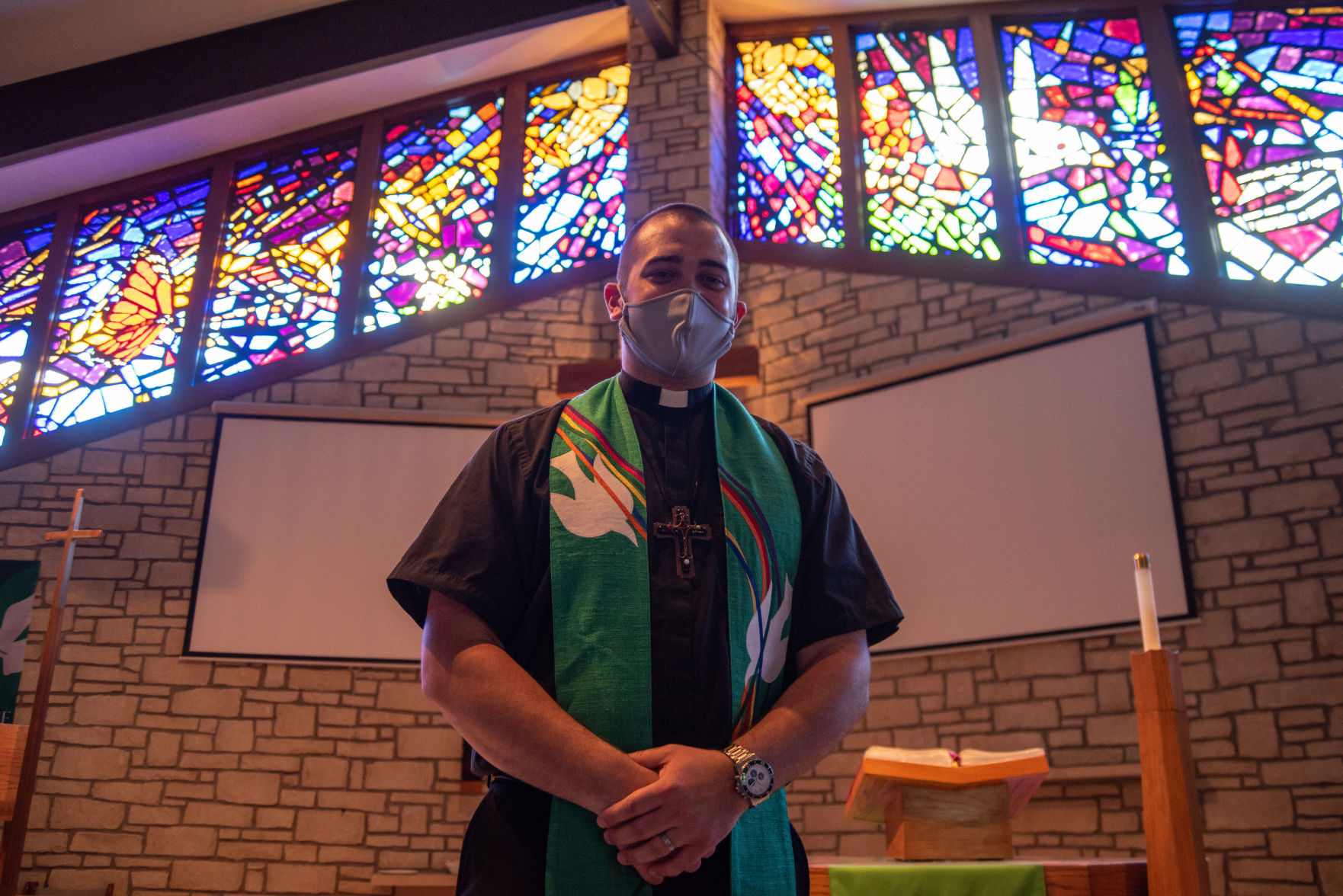 Pastor Austin English stands in front of the altar and stained glass windows, made by Maury Berggren, after SundayÕs service at Peace Lutheran Church.